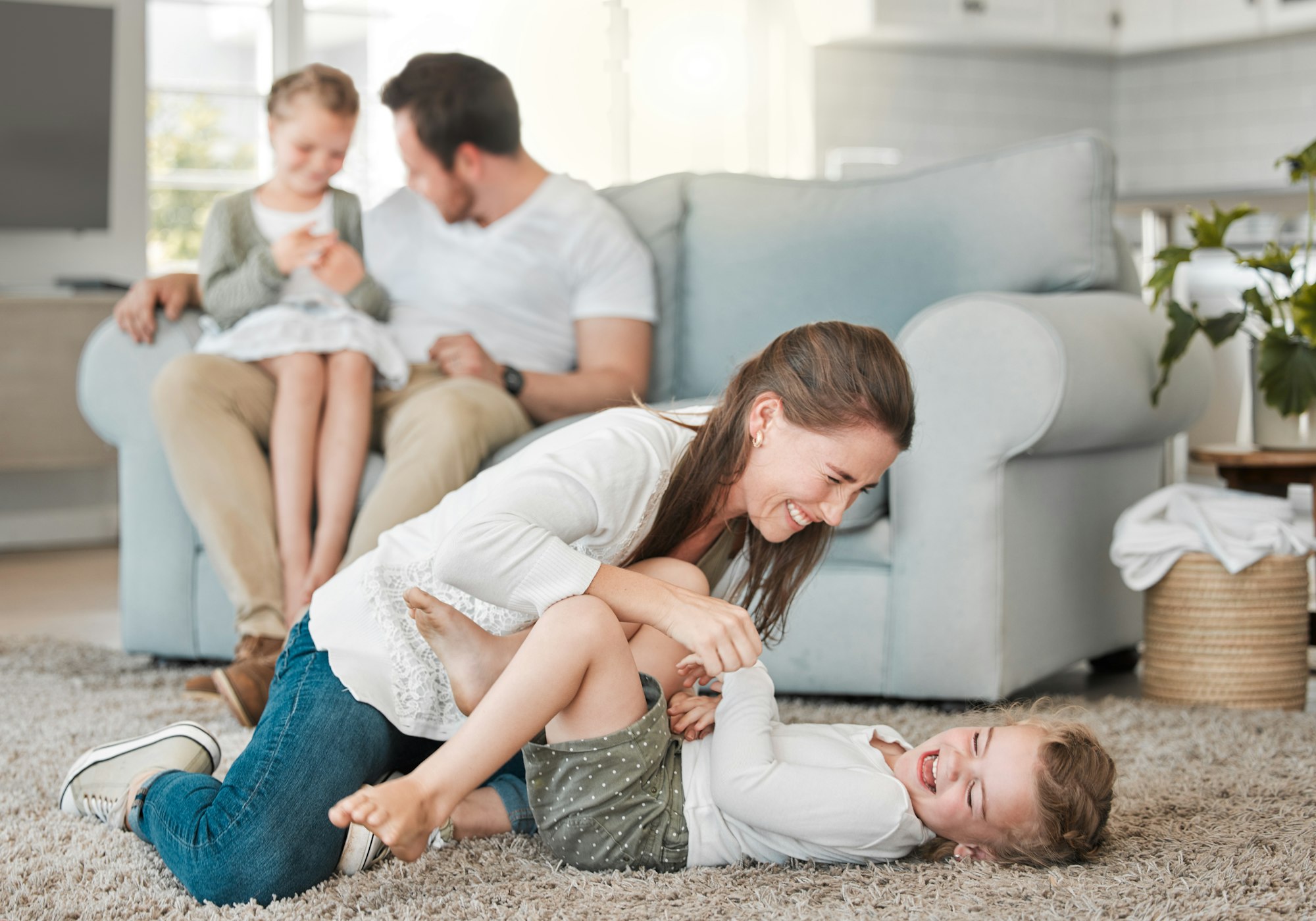 Shot of a young family playing together in the lounge at home